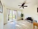 Cozy living room area with sliding glass doors, tile floors, and a ceiling fan at 2651 Andros Ln, Kissimmee, FL 34747