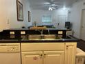 Modern kitchen with stainless steel sink, granite countertops, and ample white cabinet space at 2964 Lucayan Harbour Circ # 106, Kissimmee, FL 34746