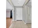 Bright entryway with neutral paint, tile floors, coat closet, and access to the living area at 3012 S Semoran Blvd # 3, Orlando, FL 32822