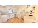 Modern kitchen featuring white cabinets, stainless steel appliances, quartz countertops, and hardwood floors at 3504 Portersfield Rd, Orlando, FL 32808