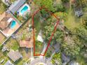 Aerial view of a property featuring a grassy, tree-filled lot with a outlined red perimeter at 444 Sunnyview Cir, Orlando, FL 32810