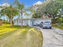 Charming single-story home with lush front lawn, palm trees, and driveway at 444 Sunnyview Cir, Orlando, FL 32810