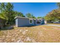 Newly renovated single-story home exhibiting a fresh gray exterior, white trim, and a spacious front yard on a sunny day at 5206 Cortez Dr, Orlando, FL 32808