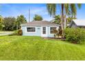 Cozy cottage-style house showcasing a neatly manicured lawn and charming curb appeal, ideal for a starter home at 6305 Bass Hwy, St Cloud, FL 34771