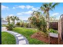 Lush backyard with a stone paver path, various plants, and landscaping, providing a tranquil outdoor space at 6439 Trailblaze Bnd, St Cloud, FL 34771