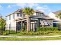 Two-story home with a mix of siding colors, a covered porch, solar panels, and manicured landscaping at 6439 Trailblaze Bnd, St Cloud, FL 34771