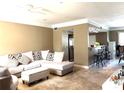 Inviting living room featuring an open floor plan and adjacent breakfast bar at 6575 Time Square Ave # 101, Orlando, FL 32835
