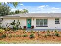 Close up of the front of the house, featuring a bright turquoise door and meticulously maintained landscaping at 7320 Fieldcrest Ave, Winter Park, FL 32792
