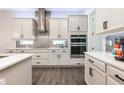 Modern kitchen with stainless steel appliances, white cabinets, stylish backsplash, and wood-look tile flooring at 10255 Beechwood Ln, Orlando, FL 32832