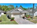 Well-kept single-story home featuring manicured lawn and brick paved driveway at 1111 Knightsbridge Cir, Davenport, FL 33896