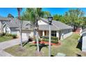 Charming home with lush landscaping, mature palm trees, and brick driveway at 1111 Knightsbridge Cir, Davenport, FL 33896