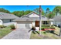 Inviting single-story home with a brick driveway and well-maintained landscaping at 1111 Knightsbridge Cir, Davenport, FL 33896