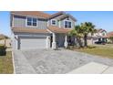 Charming home with a two-car garage, featuring a well-kept lawn and front garden at 1158 Oak Bluff Dr, Davenport, FL 33837