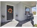 Inviting front porch with chairs, a wreath on the door, and neat landscaping at 1158 Oak Bluff Dr, Davenport, FL 33837
