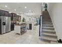 Open-concept kitchen features stainless steel appliances, island, and adjacent staircase at 1284 Pavia Dr, Apopka, FL 32703