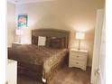 Comfortable bedroom features neutral tones, a queen-sized bed, and two nightstands with lamps at 1584 Plunker Dr, Davenport, FL 33896