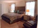 Inviting bedroom features a tufted headboard, decorative pillows, and lots of natural light at 1584 Plunker Dr, Davenport, FL 33896