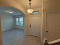 Bright foyer features stylish light fixture, neutral walls, and an arched entryway leading to the living area at 15872 Moonlight Bay St, Winter Garden, FL 34787
