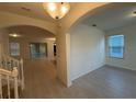 Inviting foyer boasts light walls and floors with an arched opening to the living area and view of the stairway at 15872 Moonlight Bay St, Winter Garden, FL 34787