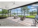 Enclosed lanai boasts beautiful lake views, comfortable seating, ceiling fans, and a brick-paved floor at 1628 Thetford Cir, Orlando, FL 32824