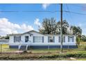 A charming manufactured home featuring white siding, blue shutters, and well-manicured landscaping at 18302 15Th Ave, Orlando, FL 32833
