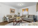 Cozy living room featuring neutral-toned sofas, a patterned rug, and a painting that adds a touch of elegance at 1924 Piedmont Ct, Mascotte, FL 34753