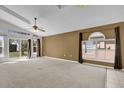 Spacious living room with high ceilings, carpet flooring, ceiling fan, and sliding glass doors to the backyard at 205 Twisting Trl, Orlando, FL 32825
