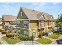 Attractive townhome showcasing neat landscaping, a red front door, and a well-maintained lawn, offering appealing curb appeal at 2624 Lodi Cir # 101, Kissimmee, FL 34746