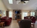 Bright living room with a brick fireplace, comfortable sofas, and a ceiling fan, creating a cozy and inviting atmosphere at 285 Ringwood Dr, Winter Springs, FL 32708