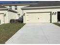 A spacious two car garage with a paved driveway and manicured lawn at 2978 Aqua Virgo Loop # 13, Orlando, FL 32837