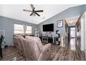 Cozy living room with modern ceiling fan, plush furnishings, hardwood floors, and vaulted ceiling at 3063 Jon Jon Ct, Orlando, FL 32822