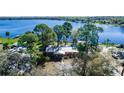 Aerial view of a cozy lake house nestled among lush trees near a serene lake at 36112 Lake Unity Rd, Fruitland Park, FL 34731