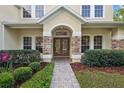 Stylish front door with stone accents and manicured landscaping at 3616 Deer Oak Cir, Oviedo, FL 32766