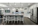 Modern kitchen with stainless steel appliances, a large island with seating, pendant lighting, and stylish backsplash at 3893 Wind Dancer Cir, St Cloud, FL 34772