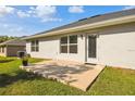 Backyard view shows concrete patio, lush green grass, and an exterior door, creating a private outdoor space at 442 Big Black Pl, Kissimmee, FL 34759