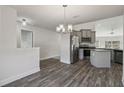 The kitchen has stainless steel appliances, a granite countertop island, and wood-look flooring at 442 Big Black Pl, Kissimmee, FL 34759