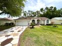 Lovely home with a patterned driveway, lush green lawn, and mature landscaping at 4638 River Ridge Dr, Leesburg, FL 34748