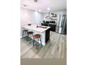 Bright kitchen with stainless steel appliances, counter seating, and wood look vinyl plank flooring at 5237 Davisson Ave, Orlando, FL 32810