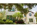 Stately two-story home with brown trim, a manicured lawn, and mature tropical landscaping at 6008 Golden Dewdrop Trl, Windermere, FL 34786