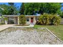Charming single-story home featuring a red front door and a well-maintained, rock landscaped front yard at 6031 W Ridgewood Ave, Orlando, FL 32835