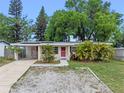 Charming single-story home featuring a red front door and a well-maintained, rock landscaped front yard at 6031 W Ridgewood Ave, Orlando, FL 32835