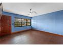 Inviting living room with hardwood floors, a ceiling fan, and a large window at 6031 W Ridgewood Ave, Orlando, FL 32835