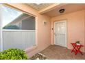 Charming home exterior featuring a covered entryway, large window, and colorful front door at 613 Nuevo Leon Ln, The Villages, FL 32159