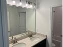 Elegant bathroom featuring double sinks, a granite countertop, and modern lighting fixtures at 725 Ginger Dr, Haines City, FL 33844