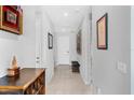 Bright hallway featuring tiled floors, neutral walls, decorative wall art and ample natural lighting at 7633 Agrigento St, Clermont, FL 34714