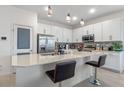 Modern kitchen with white cabinets, stainless steel appliances, mosaic backsplash, quartz countertops, and pendant lighting at 861 Grazie Loop, Davenport, FL 33837