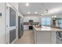 Bright kitchen with white cabinets, a stainless steel refrigerator, an island, and tile floors in an open-concept layout at 861 Grazie Loop, Davenport, FL 33837