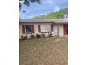 Charming single-story home with a red-trimmed roof, attached garage, and small front yard at 904 Hickory Ave, Fruitland Park, FL 34731