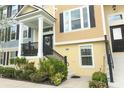 Inviting townhouse entrance with well-maintained landscaping, a cozy porch, and elegant black railings at 1011 Cedar Bay Ln, Winter Springs, FL 32708