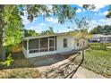 View of charming single-story home with a screened porch and landscaped front yard at 1179 Seminole St, Clermont, FL 34711